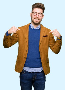 Yüzünde gülümseme ile kendinden emin görünüyorsun, kendini gururlu ve mutlu parmakları ile işaret gözlüklü genç yakışıklı iş adamı.