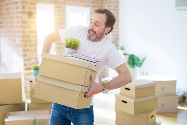 Bonito homem nervoso sênior de meia idade tentando segurar papelão — Fotografia de Stock