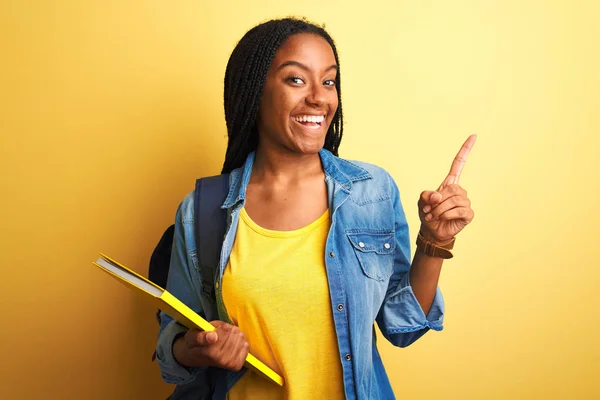 Afrikanisch Amerikanische Studentin Trägt Rucksack Und Buch Über Isoliertem Gelben — Stockfoto