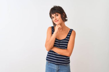 İzole edilmiş beyaz arka plan üzerinde duran çizgili tişört giyen genç ve güzel bir kadın kameraya kollarını kavuşturup ve çenesini kaldırarak gülümsüyor. Olumlu düşünüyorum..