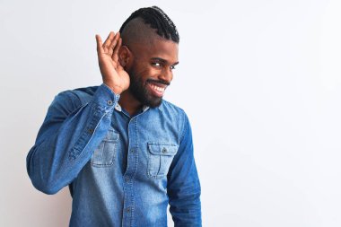 Örgülü, beyaz arka planda kot gömlek giyen, ağzı kulaklarına varan bir gülümsemeyle dedikoduları ya da dedikoduları dinleyen Afro-Amerikan bir adam. Sağırlık kavramı.