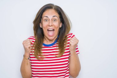 Orta yaş yaşlı kadın beyaz izole arka plan üzerinde ayakta sürpriz ve kollarını kaldırdı ve açık gözleri ile başarı için hayran kutluyor. Kazanan kavramı.