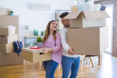 Yeni ev, yeni bir daire için çok mutlu ve neşeli karton kutular tutarak hareket aşk genç güzel çift