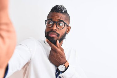 Afrika kökenli Amerikalı iş adamı, izole edilmiş beyaz arka plan üzerinden özçekim yapıyor. Ciddi bir yüz. Soru üzerine kafa karıştırıcı bir düşünce.
