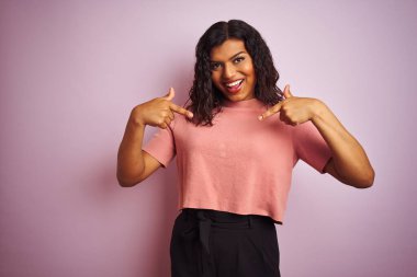 Genç, güzel transseksüel, zarif bir kadın pembe arka planda, kendine güvenen, yüzünde bir gülümsemeyle, gururlu ve mutlu bir şekilde kendini gösteren..