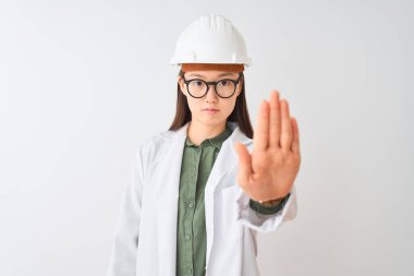 Genç Çinli mühendis kadın, izole edilmiş beyaz arka planda gözlük takıyor ve avucunun içi gibi şarkı söylemeyi kesiyor. Yüzünde olumsuz ve ciddi bir jest olan uyarı ifadesi.