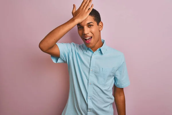 年轻英俊的阿拉伯男子穿着蓝色的衬衫 站在孤立的粉色背景上 对手头上的错误感到惊讶 记住错误 记性差 — 图库照片
