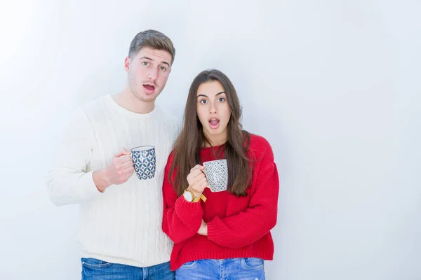 Casal Jovem Bonito Sobre Fundo Isolado Branco Bebendo Uma Xícara — Fotografia de Stock