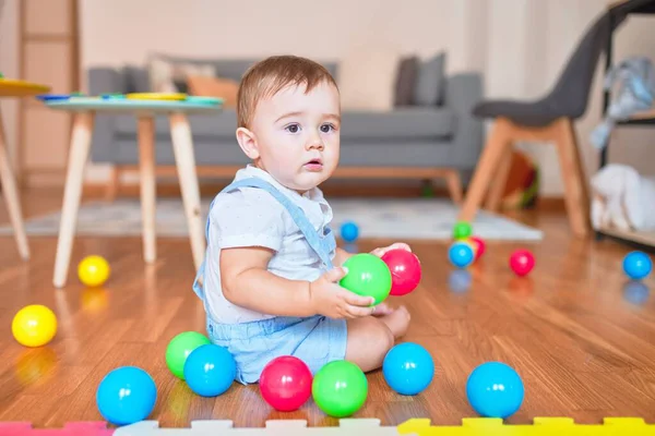 幼稚园时 漂亮的幼儿坐在地板上 与五彩缤纷的小球玩耍 — 图库照片