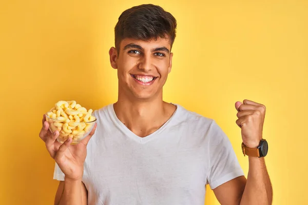 Young Indian Man Holding Bowl Extruded Corn Standing Isolated Yellow — Stock Photo, Image