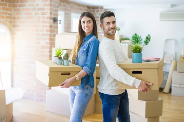 年轻夫妇搬到新家 面带微笑 高兴地在新公寓拿着纸板箱 — 图库照片