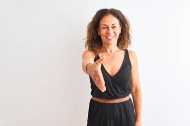 İzole edilmiş beyaz arka planda duran siyah, sıradan bir elbise giyen orta yaşlı bir kadın dostça bir selamlama ve hoş geldin hediyesi olarak el sıkışma sunuyor. Başarılı bir iş..