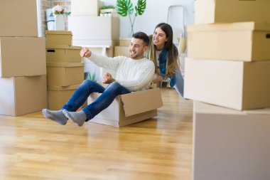 Genç çift yeni bir eve hareket, eğlence sürme karton kutular