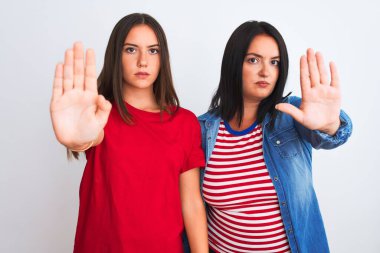 İzole edilmiş beyaz arka planda durup avuçlarıyla şarkı söylemeyi kesen gündelik giysiler giyen genç ve güzel kadınlar. Yüzünde olumsuz ve ciddi bir jest olan uyarı ifadesi.