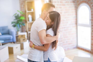 Karton kutular etrafında yeni evde sarılma genç güzel çift