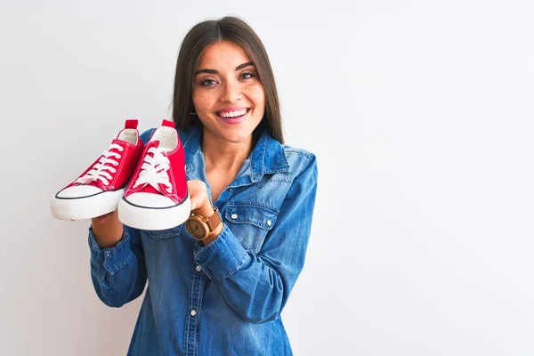 Joven Mujer Hermosa Sosteniendo Zapatillas Informales Pie Sobre Fondo Blanco —  Fotos de Stock
