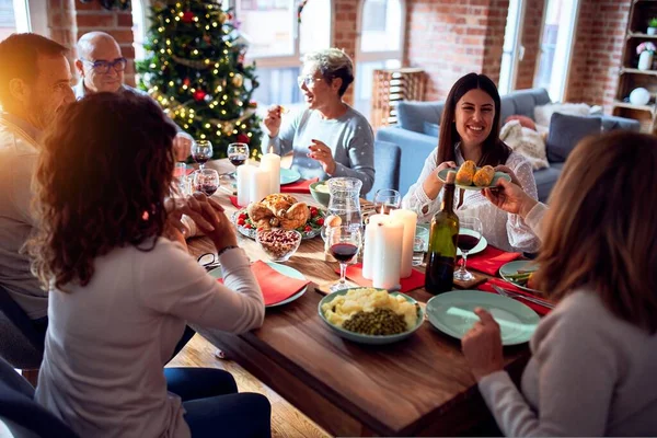 伝統的な料理と装飾でクリスマスの前夜を祝う家で家族や友人の食事 ロマンチックなシニアカップルが一緒にソファに座って話しています — ストック写真