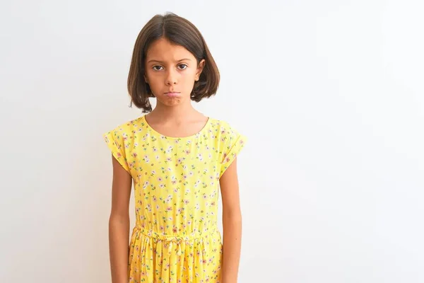 年轻美丽的小女孩穿着黄色的花衣服站在孤立的白色背景上 沮丧而忧心忡忡 愤怒而又害怕 悲伤的表情 — 图库照片