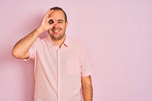 셔츠를 고립된 분홍색 손으로 웃음을 얼굴로 손가락을 응시하는 — 스톡 사진