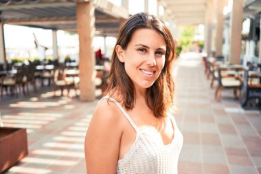 Romantik köyde genç ve güzel bir kadın güneşli bir günde kasaba sokaklarında yürüyor.