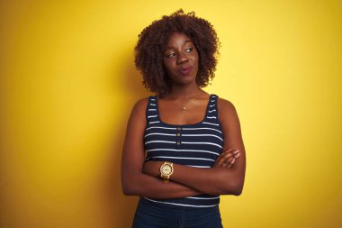 İzole edilmiş sarı arka plan üzerinde çizgili tişört giyen Afrikalı genç bir kadın gülümsüyor ve şöyle düşünüyor:.