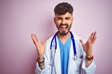 Stethokop takan genç bir doktor, izole edilmiş pembe arka planda dikilip kollarını kaldırıp heyecanla haykırarak başarının çılgınlığını kutluyor. Kazanan konsept