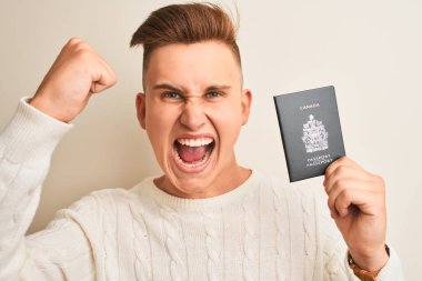 Kanada pasaportu taşıyan yakışıklı genç adam izole edilmiş beyaz bir arka planda sinirli ve hayal kırıklığına uğramış öfkeyle bağırıyor, deli gibi bağırıyor ve el kaldırarak bağırıyor.