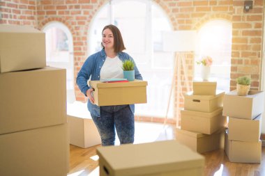 Genç güzel artı boyutu kadın yeni bir eve hareket, tutarak c