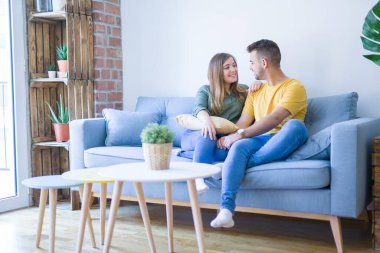 Evde kanepede aşık genç güzel çift oturan