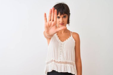 Yaz tişörtü giyen genç ve güzel bir kadın izole edilmiş beyaz arka planda durup avuç içiyle şarkı söylemeyi kesiyor. Yüzünde olumsuz ve ciddi bir jest olan uyarı ifadesi.