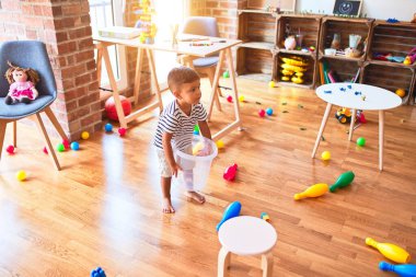 Anaokulunda plastik sepetle oynayan güzel çocuk.