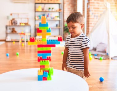 Güzel çocuk anaokulunda inşaat bloklarıyla oynuyor.