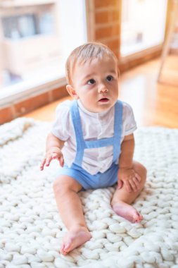 Anaokulunda battaniyenin üzerinde oturan güzel çocuk.