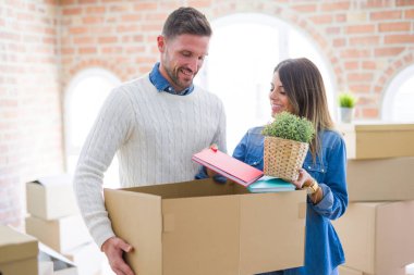 Karton kutuların etrafında duran genç ve güzel bir çift. 