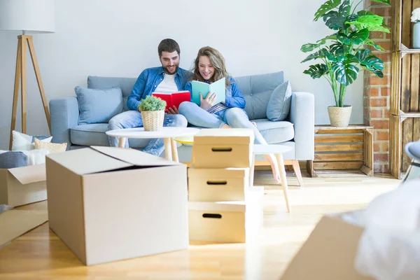 Pareja Joven Relajándose Sofá Leyendo Libro Tomando Descanso Para Mudarse — Foto de Stock