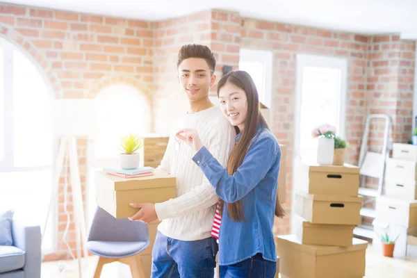 Jovem asiático casal segurando chaves de nova casa, sorrindo feliz e — Fotografia de Stock