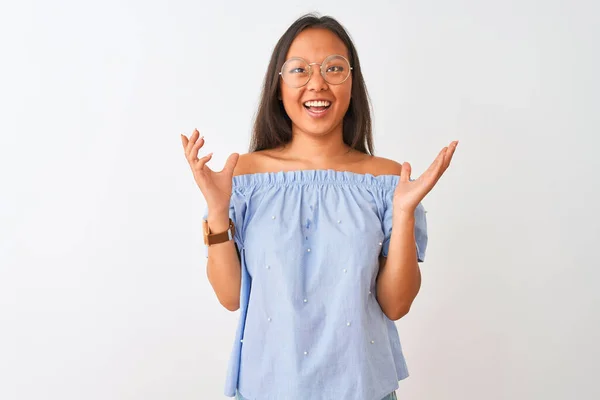 年轻的中国女人穿着蓝色的T恤 戴着眼镜 站在孤立的白色背景上疯狂地大叫着 带着咄咄逼人的表情和胳膊大喊大叫 沮丧的概念 — 图库照片