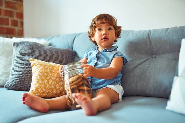 Menina Criança Bonita Segurando Frasco Biscoitos Sentados Sofá — Fotografia de Stock