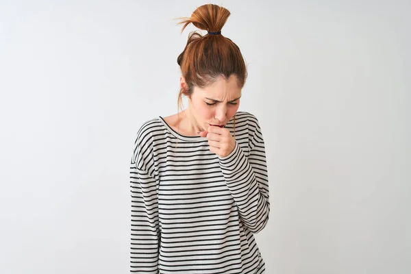 Redhead woman wearing navy striped t-shirt standing over isolated white background feeling unwell and coughing as symptom for cold or bronchitis. Healthcare concept.