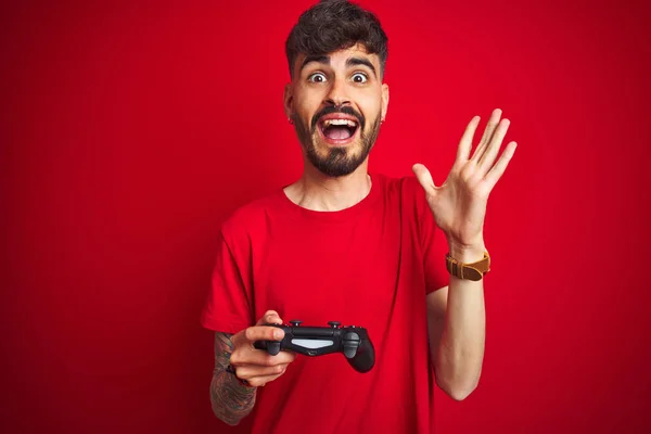 Jovem Jogador Homem Com Tatuagem Jogando Videogame Sobre Fundo Vermelho — Fotografia de Stock