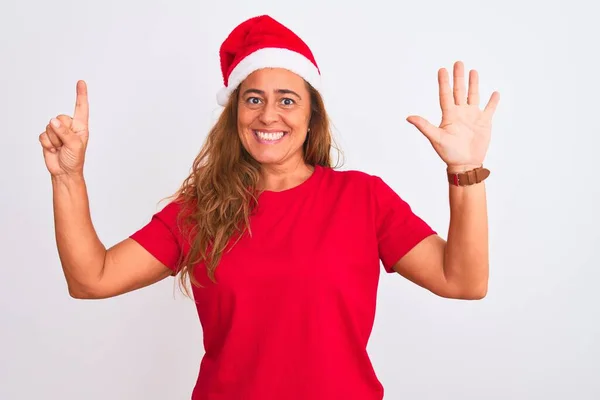 中年成熟した女性身に着けていますクリスマス帽子上の隔離された背景ショーとポイントアップとともに指番号6ながら笑顔自信と幸せ — ストック写真