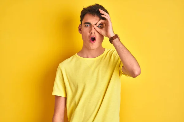 10代の少年は 孤立した背景の上に黄色のTシャツを着て 驚きの顔でショックを受け 目の指を見て をジェスチャーを行う 不信仰の表現 — ストック写真
