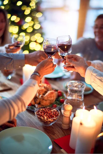 Family and friends dining at home celebrating christmas eve with traditional food and decoration, all sitting on the table together