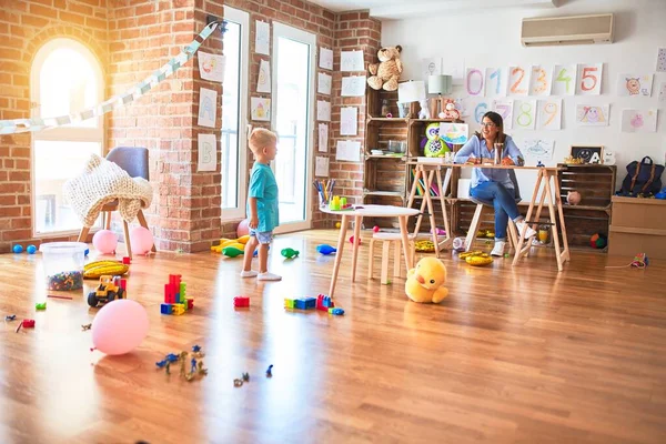 Jovem Criança Caucasiana Brincando Playschool Com Professor Jovem Sentada Mesa — Fotografia de Stock