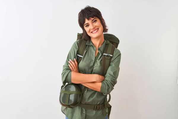 Beautiful hiker woman wearing backpack and water canteen over isolated white background happy face smiling with crossed arms looking at the camera. Positive person.