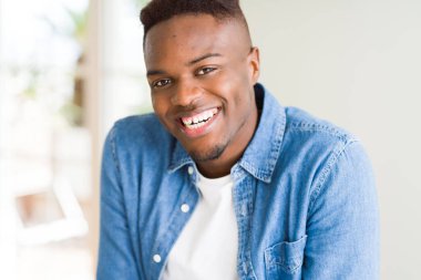 Gülümseyen yüzünde kocaman bir gülümseme ile neşeli Afrika yakışıklı genç