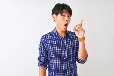 Sıradan mavi gömlekler giyen genç Çinli adam izole edilmiş beyaz arka planda durup başarılı bir fikir işaret ediyor. Heyecanlı ve mutlu. Bir numara..