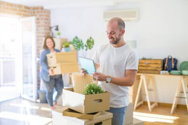 Karton kutuların etrafında genç bir çift yeni bir eve taşınıyor