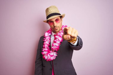 Takım elbiseli genç işadamı gözlüklü Hawai zambağı izole edilmiş pembe arka planda kamerayı işaret ediyor ve sen, el işareti, ön taraftan pozitif ve kendinden emin bir hareket.