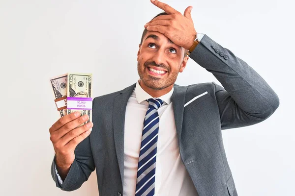 Młody Przystojny Biznesmen Trzymający Kupę Banknotów Odosobnionym Tle Zestresowany Ręką — Zdjęcie stockowe